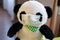 Soft toys, a panda sitting in a crib in medical mask.