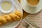 Soft twist bread dipping with sweetened condensed milk and coffee cup