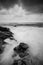 Soft wave flow hitting the sandy beach over dark cloud background. soft focus image due to long exposure shot