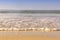 Soft wave from sea come to wet sand beach with blur clear sky background. With copy space for text or design