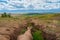 Soil erosion, deep ravine in the distance. Scenic view to colorful unusual relief. Picturesque gorge in highlands