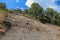 Soil erosion in the highlands. Landscape mountain with soil cracked. Rock outlier on background of mountains with forests, which a