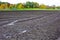 Soil before planting. Furrows row pattern in a plowed field prepared for planting. Farming field