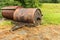 Soil roller for the handling and laying of the lawn. Old rusty metal lawn roller on some dry grass. Vintage roller for sports