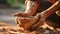 Soiled hand shaping clay in an outdoor workshop