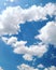 In the solar blue sky white cumulus clouds in the form of heart