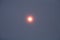 The solar disk shining through the smoky atmosphere.