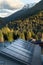 Solar energy panels on house roofs near cascading green mountains in the daytime, vertical shot