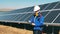 Solar energy specialist monitoring solar farm using his tablet