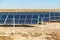 Solar field with fenced solar panels at sunset