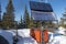 Solar Panel, Green Renewable Energy Equipment in Snow with Forest Background