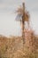 Solar panel on a pole wrapped in dry vegetation