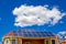 Solar panel on a red roof reflecting the sun and blue sky