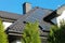 Solar panel on a red roof reflecting the sun and the cloudless blue sky