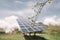 Solar panels are in the garden near the summer house. Extraction of solar energy for the home in the garden. Trees bloom on the