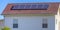 Solar panels mounted on the red rooftop of a home