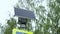 Solar panels and road sign with built-in flashing yellow traffic light. Close-up