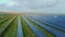 Solar panels at a suburban solar power plant. Farm fields on the background. Silicon photovoltaic cells in