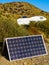 Solar photovoltaic panel and camper in the distance