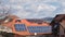 Solar photovoltaic panels on suburban house roofs with clouds in time lapse above. Clean energy concept in the city.