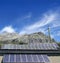 Solar plates and windmill under blue sky