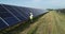 Solar power engineer working on a solar farm. Drone shot