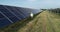 Solar power engineer working on a solar farm. Drone shot