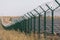 Solar power station protected from road by barbed wire fence. Fencing of sensitive sites with barbed wire