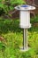 Solar-powered lamp on garden background.