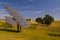 Solar trackers and trees on the plowed field