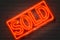 Sold, neon sign on brick wall