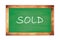 SOLD text written on green school board