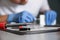 Soldering iron in focus and blurred technician repairing mobile phone at table, closeup