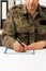 Soldier hand using a pen