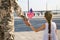 Soldier and his little daughter with American flag holding hands outdoors, back view. Veterans Day in USA