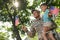 Soldier and his little son with American flags outdoors, low angle view. Veterans Day in USA