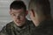 Soldier looks somber while being consoled by peer, horizontal