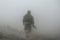 Soldier in military gear walking into fog