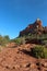 Soldier Pass Trail leading to a red sandstone mountain with evergreens growing up the slope in Sedona