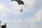 Soldier rappelling from helicopter in blue sky