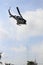 Soldier rappelling from helicopter in blue sky with blur propeller