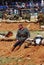 A soldier-reenactor sits on the ground, he looks tired.