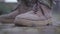 Soldier`s laced up boots close up. Shoelaces fluttering in the wind. Military boots on the man`s feet. Military and