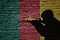 Soldier silhouette on the old brick wall with flag of cameroon country