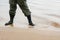 A soldier in special military clothes and boots stands in the water