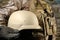 Soldier in uniform holding armor helmet in desert