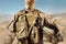 Soldier in uniform standing in desert background with helmet