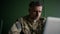 Soldier working with laptop in home. Everyday life of a military man in reserve. Work and communication online