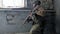 Soldiers in camouflage with a military weapon aiming through the rifle sight through the window of an old building, the