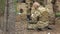 Soldiers in camouflage prepare for battle and check out equipment and weapons